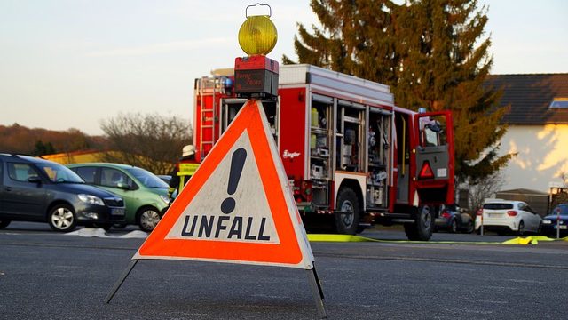 Ein Unfall-Warnschild vor einem Feuerwehrauto