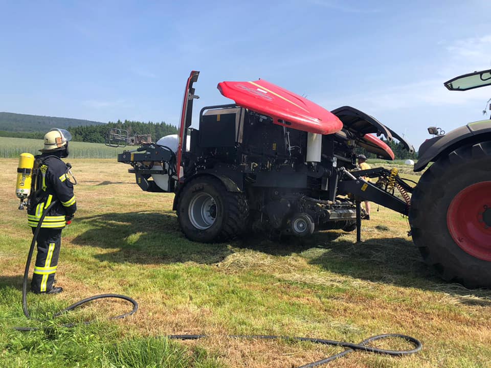 Feuerwehr löscht Brand einer Rundballenpresse in Schwarzenbach