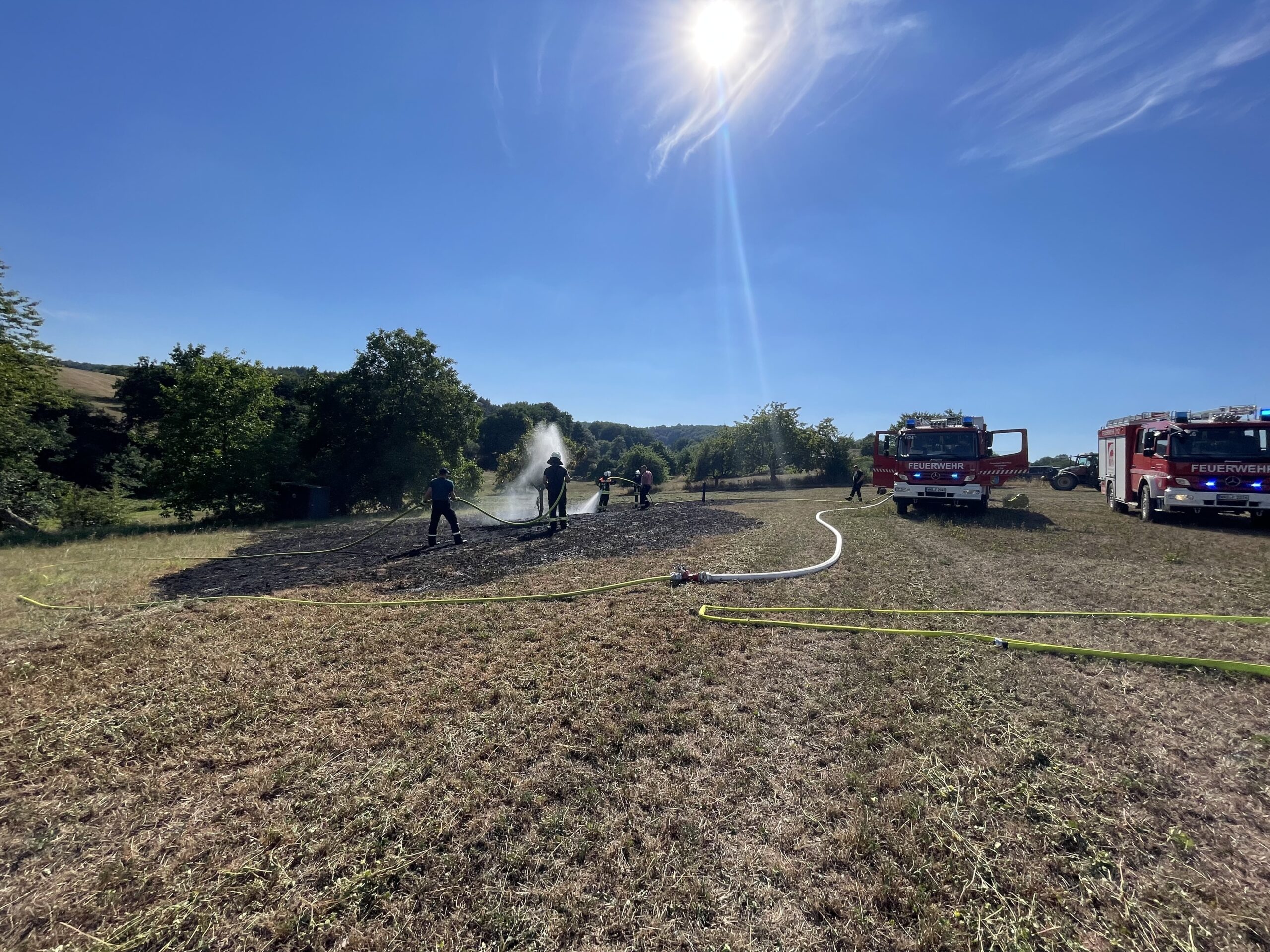 Feuerwehrleute löschen einen kleinen Flächenbrand.