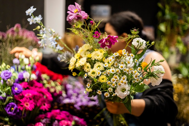 Floristin bei der Arbeit mit Blumenstrauß in der Hand