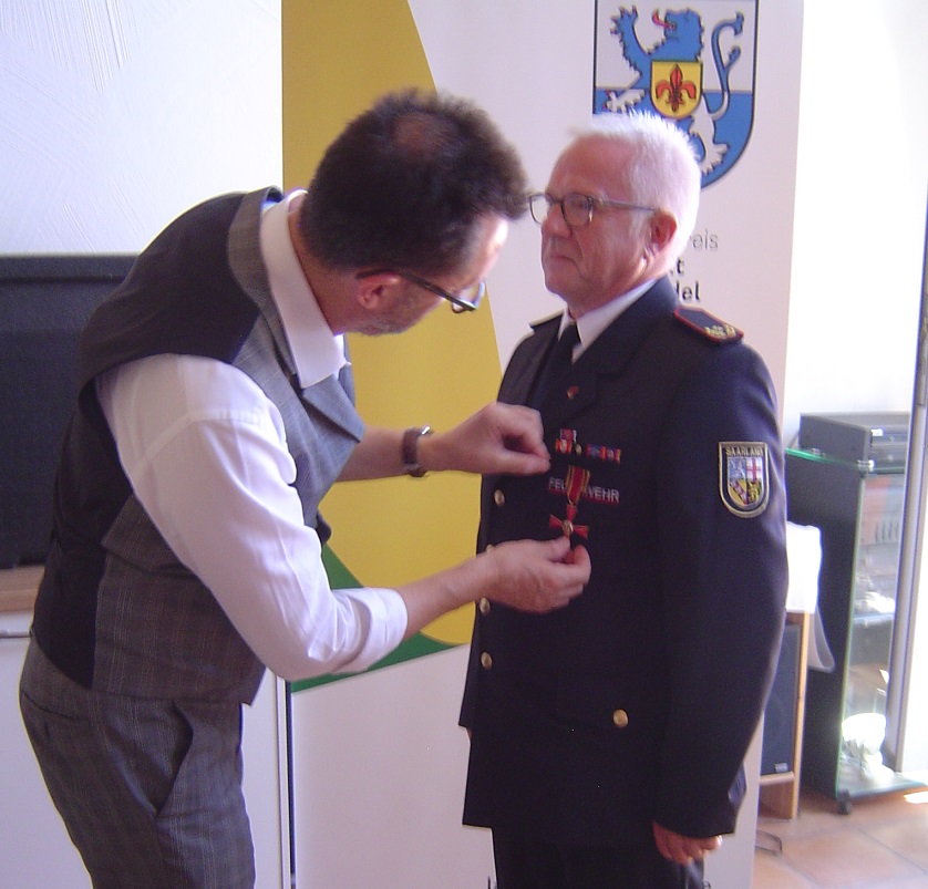 Der saarländische Innenminister Reinhold Jost zeichnet Frank Feid mit dem Bundesverdienstkreuz aus.