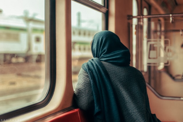 Frau mit einem Kopftuch sitzt in einem Zug