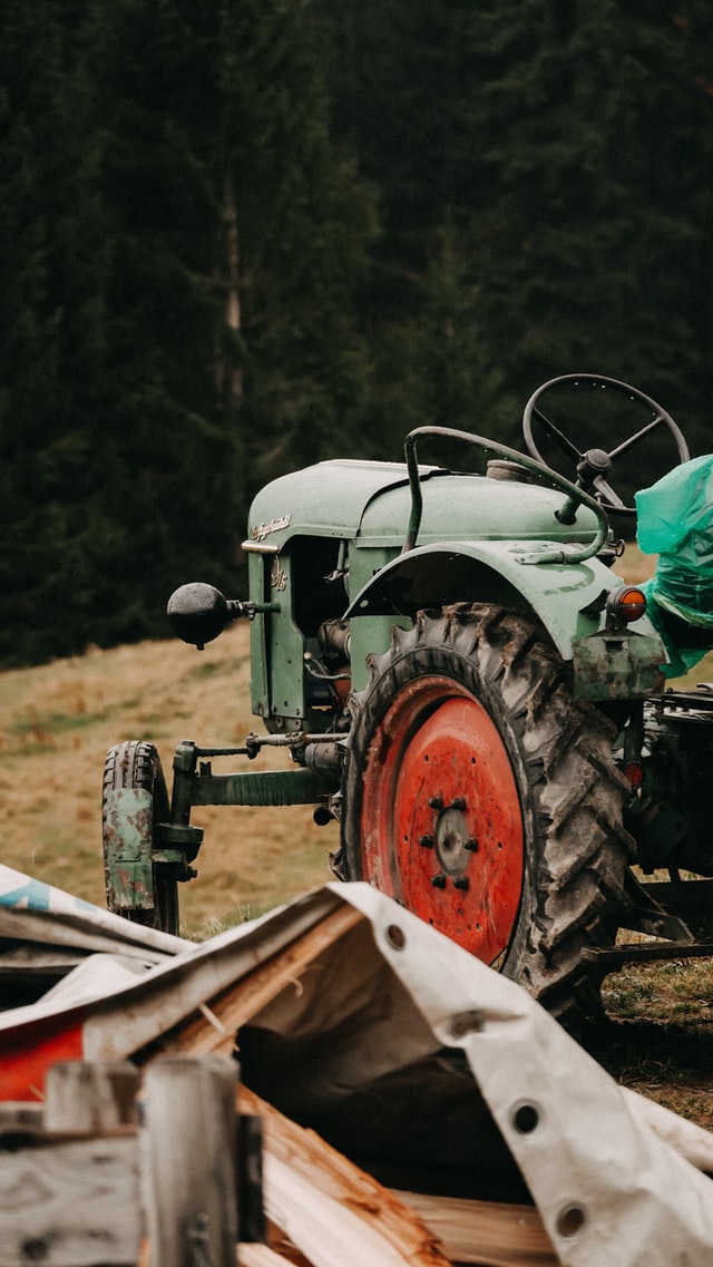grüner Traktor steht auf einem Feld (Symbolbild)