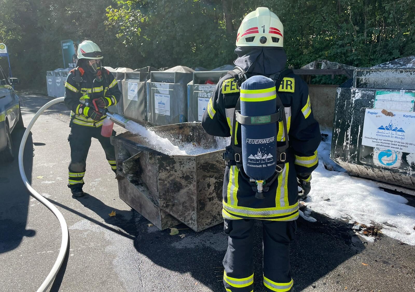zwei feuerwehrmänner st. wendels löschen einen containerbrand