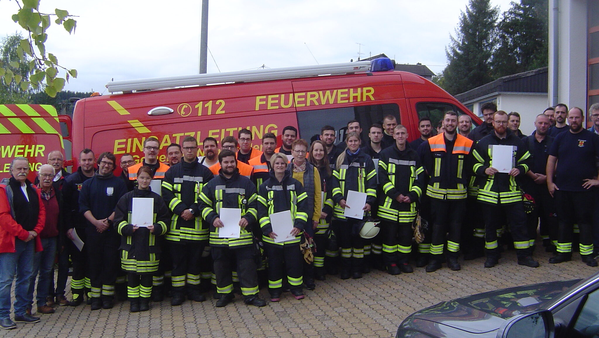 die neuen maschinisten vor dem auto der feuerwehr