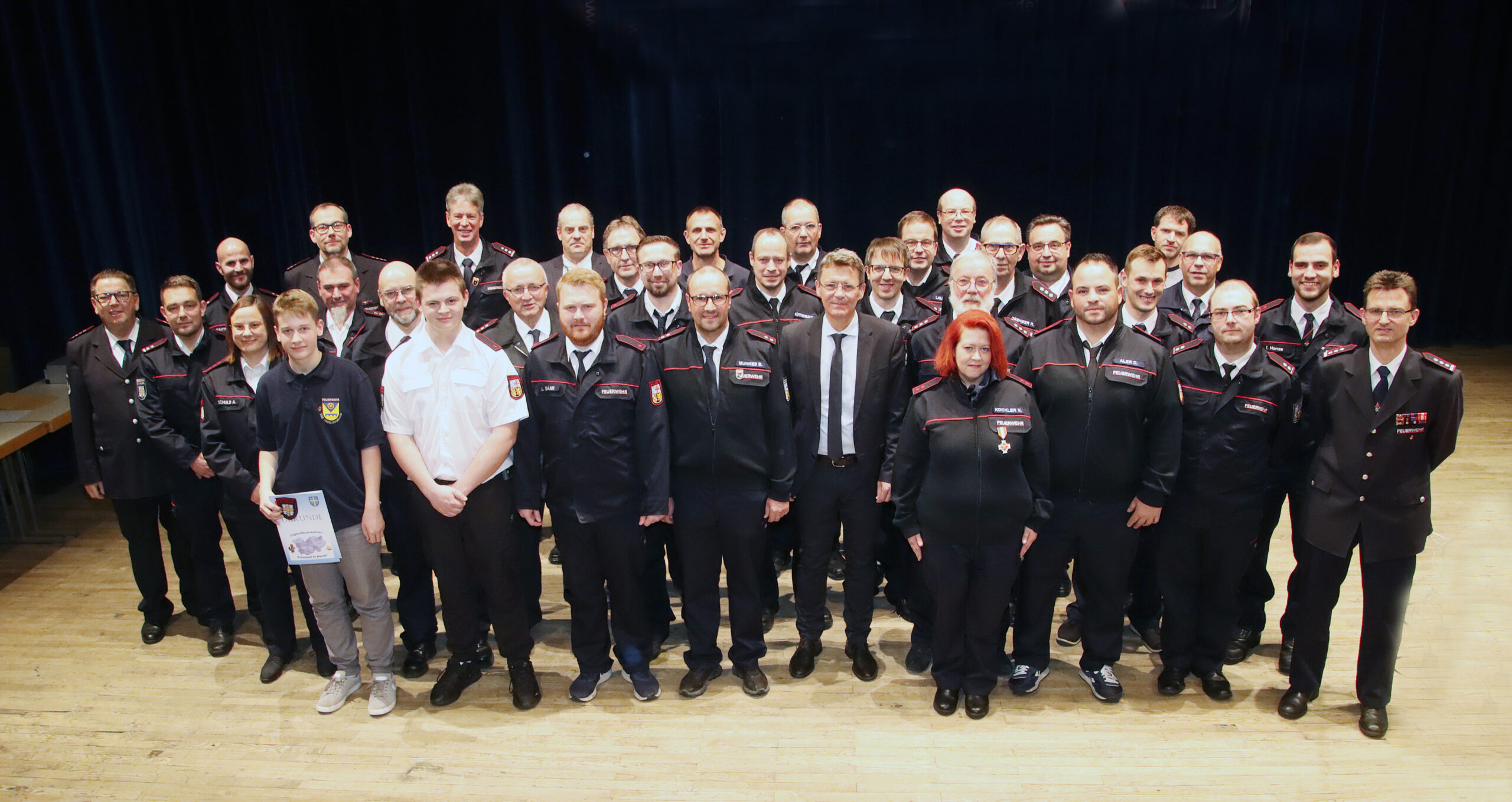 Die gehehrten und beförderten Feuerwehrleute auf der Bühne des St. Wendeler Saalbaus.