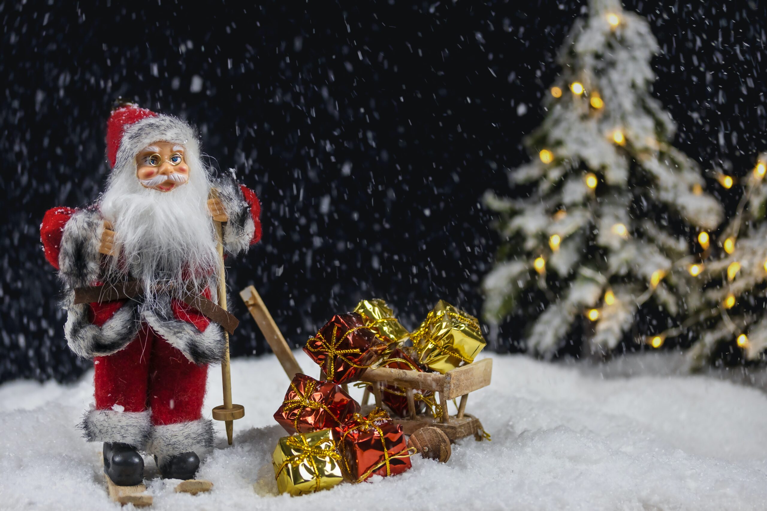 ein nikolaus neben den geschenken im schnee