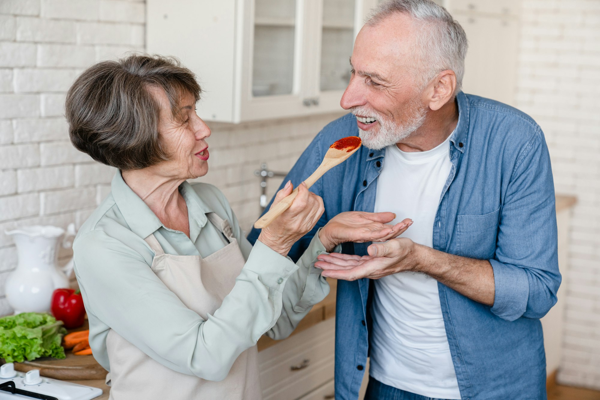 Caucasian senior elderly old couple spouses grandparents cooking together, preparing food