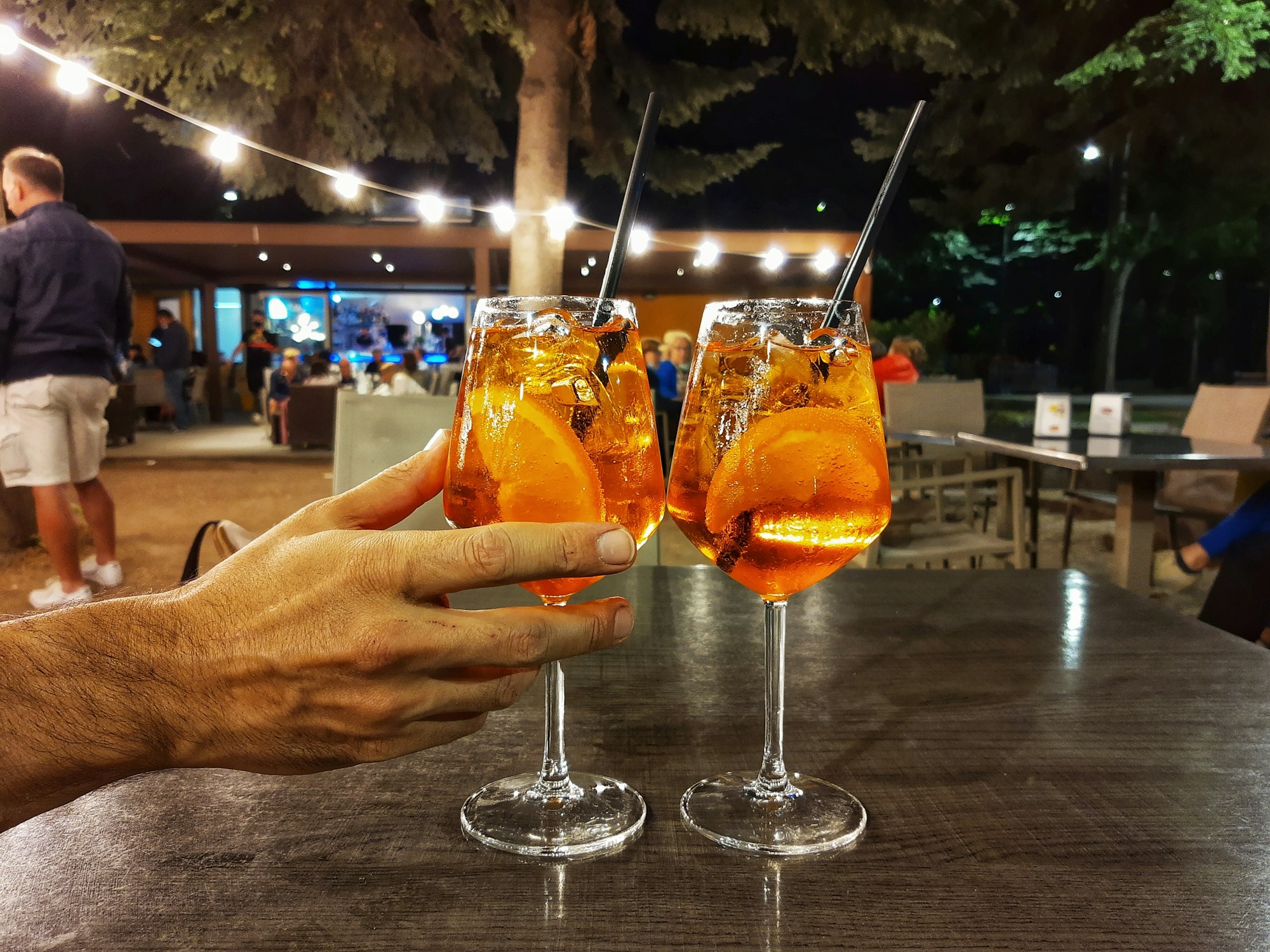 Two aperol spritz cocktails in a bar outdoors