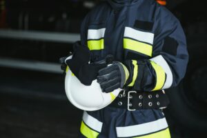 Portrait of a firefighter standing in front of a fire engine
