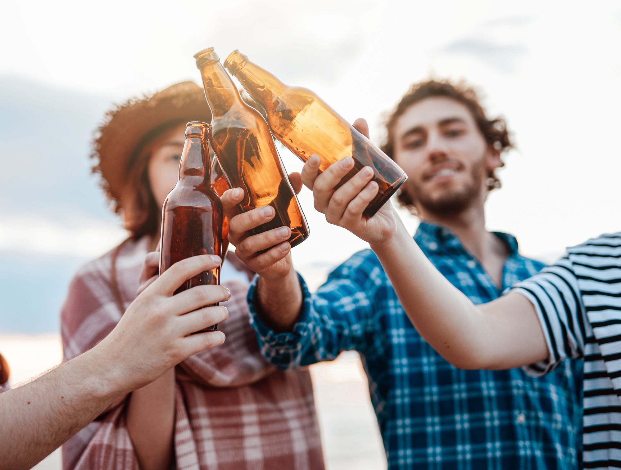 Friends drink beer on the beach