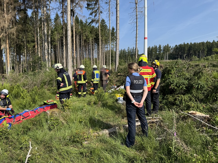 Feuerwehr- und Polizeiangehörige kümmern sich um die Rettung der verletzten Person.