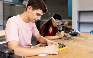 Diverse young high school students learning in science robotics electronic class