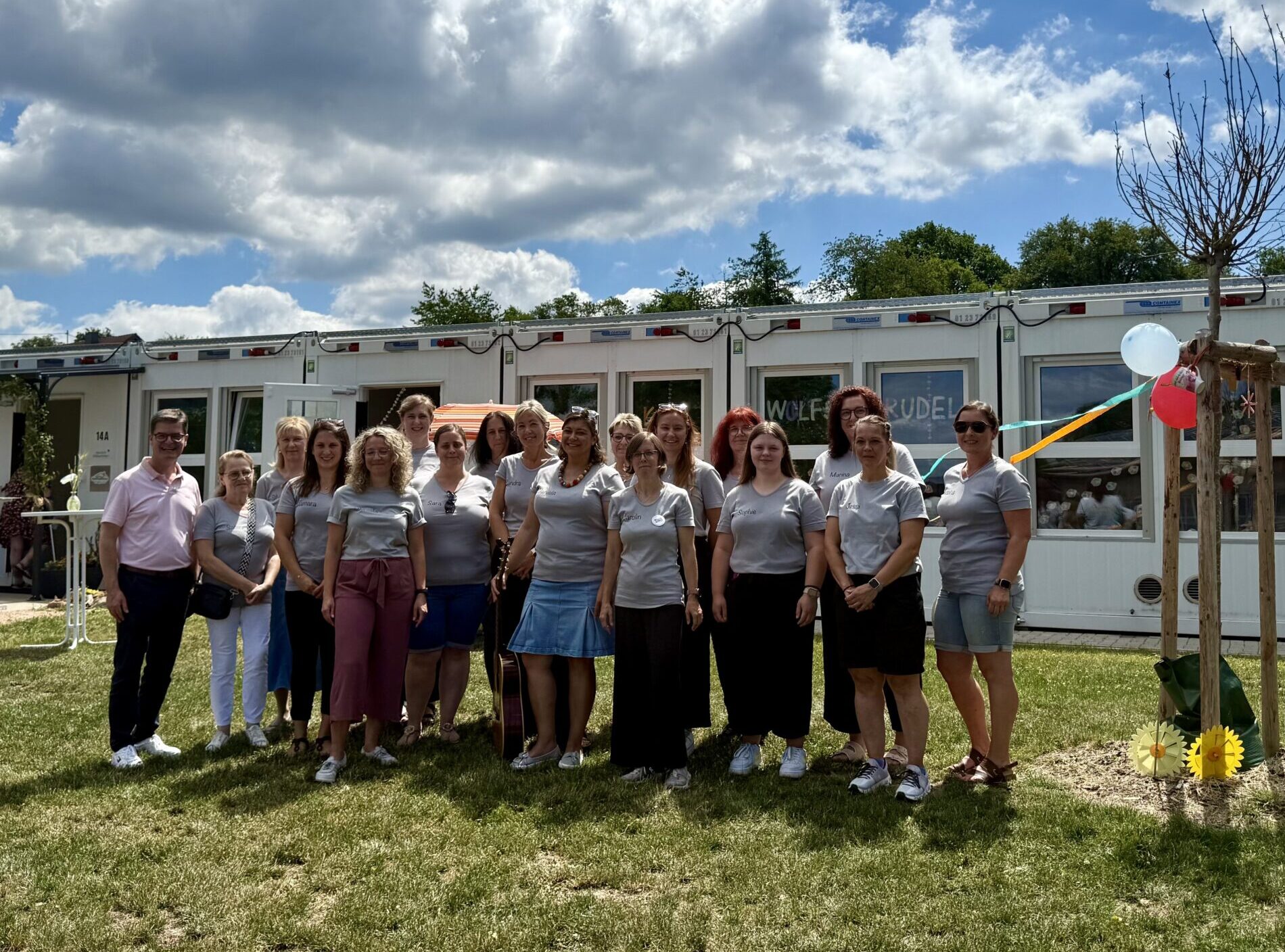 Eröffnung der Kita Wolfersweiler auf dem Bildist das Personla des Kindergartens und Bürgermeister Veit zu sehen vor dem Provisorium der Stätte